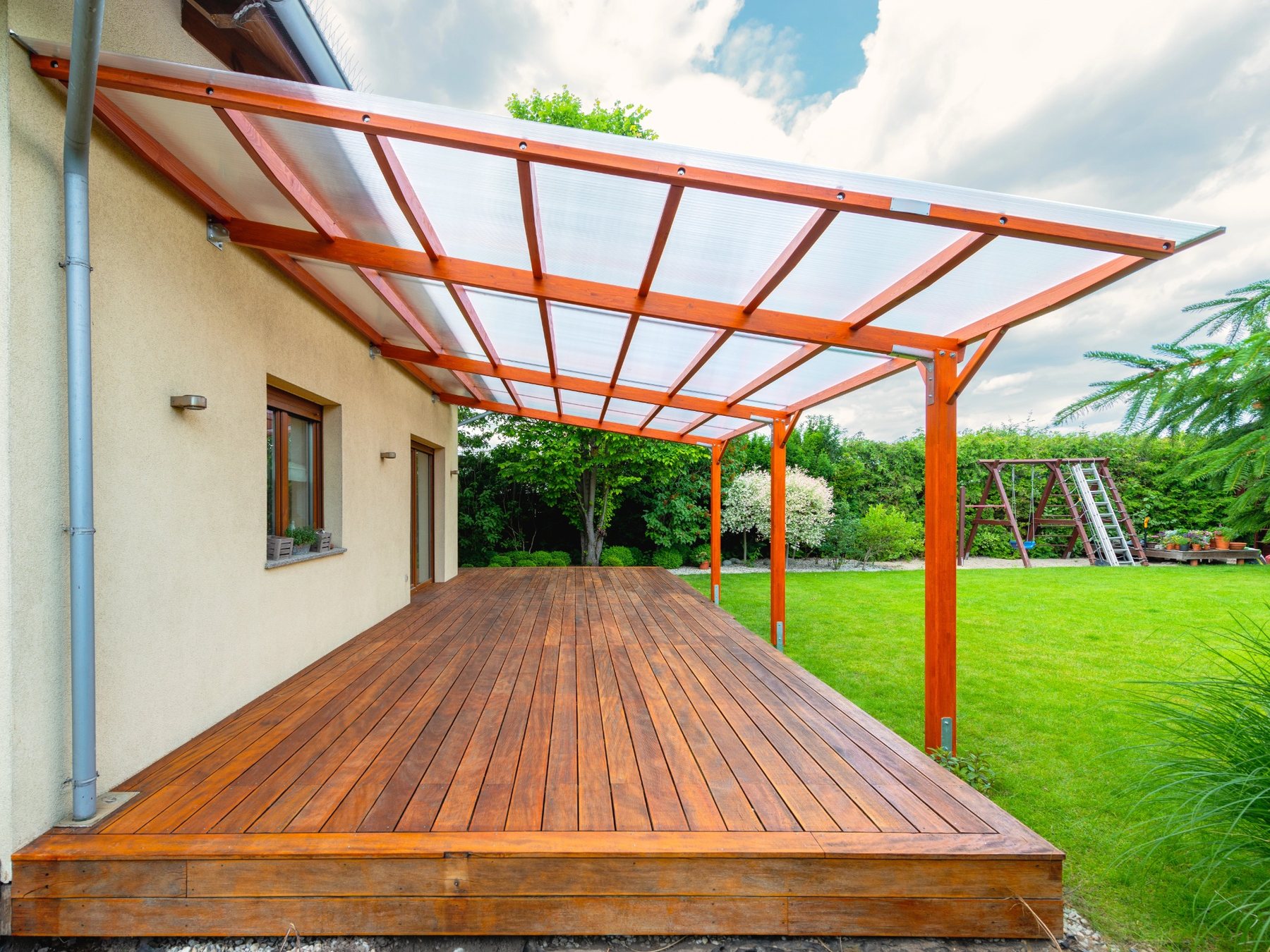 Holzterrasse mit passender Terrassenüberdachung aus Holz und lichtdurchlässigem Dach
